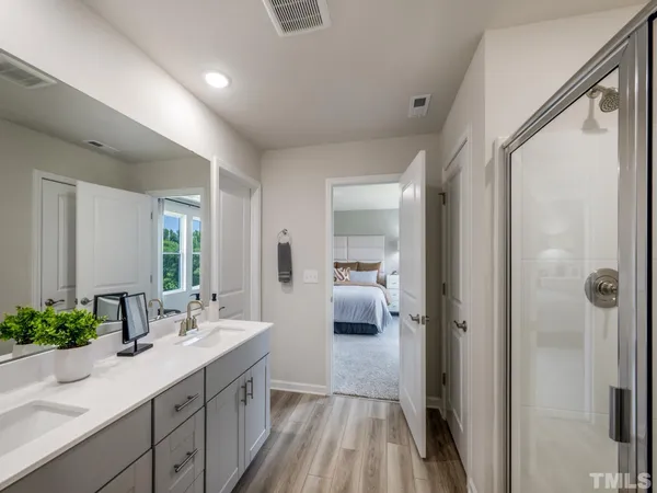 a en suite bathroom with a sink mirror and shower