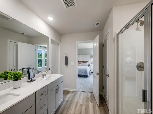 a en suite bathroom with a sink mirror and shower