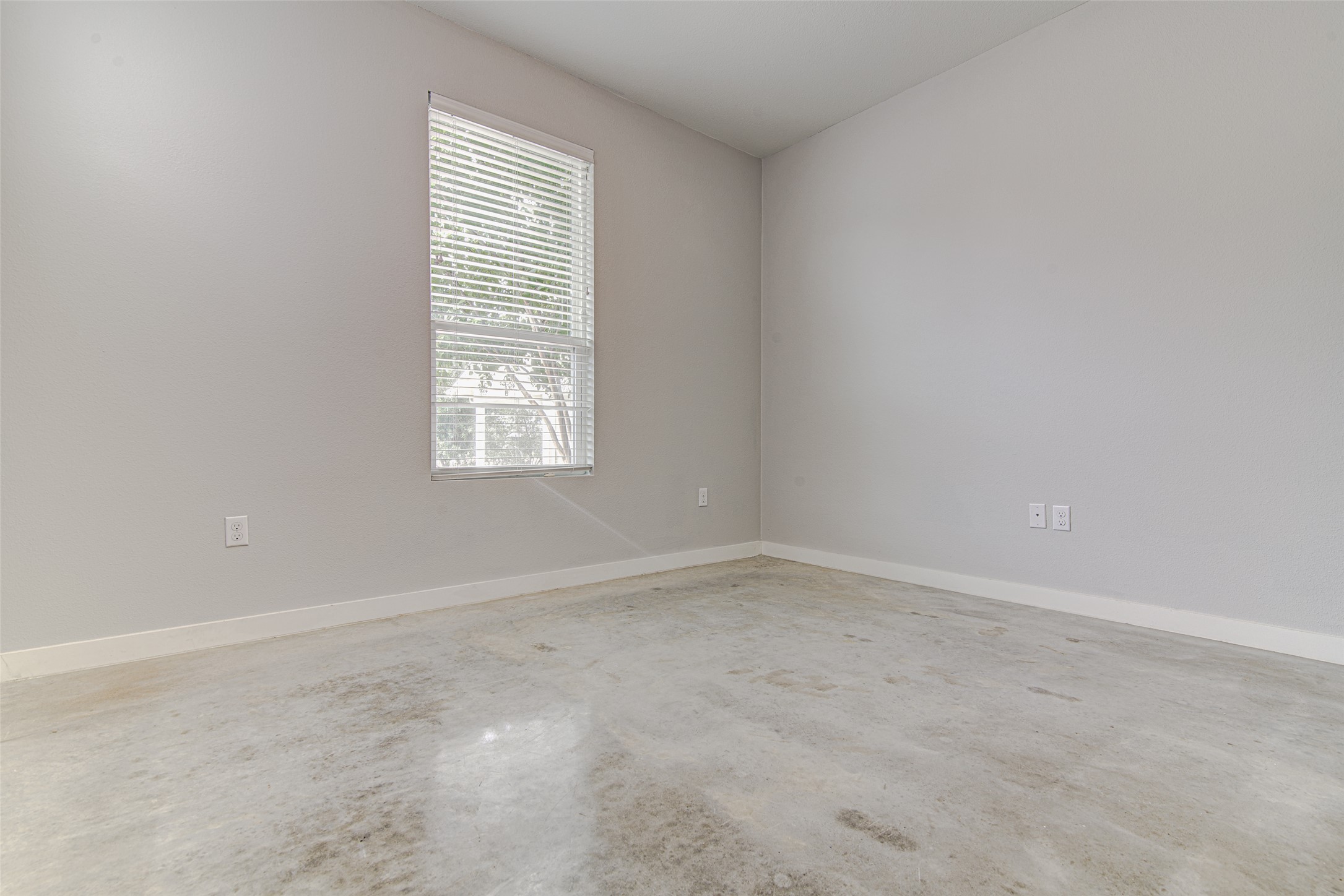 1904 Bunche Road, Unit B Austin, TX 78721 - Photo 20 of 29 Downstairs bedroom with polished concrete floors, a large closet, and plenty of room for a queen-size bed, with flexible space for a bedroom, office, or guest room.