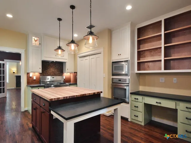 a kitchen with kitchen island a counter top space appliances and cabinets