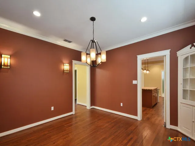 a view of a room with wooden floor staircase and a kitchen
