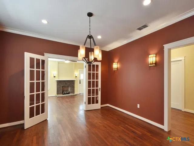 a kitchen with a stove center island a sink cabinets and wooden floor