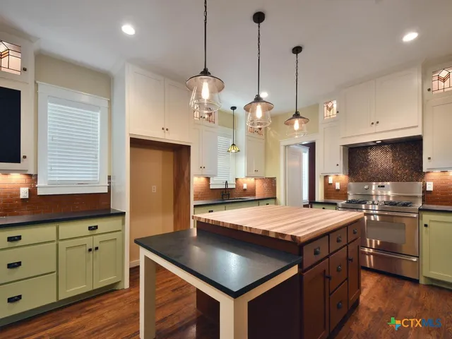 a kitchen with stainless steel appliances granite countertop a stove and a sink