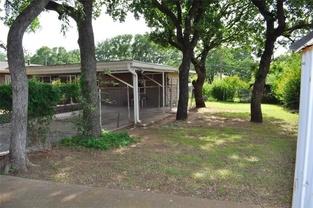 a view of a house with backyard and a tree