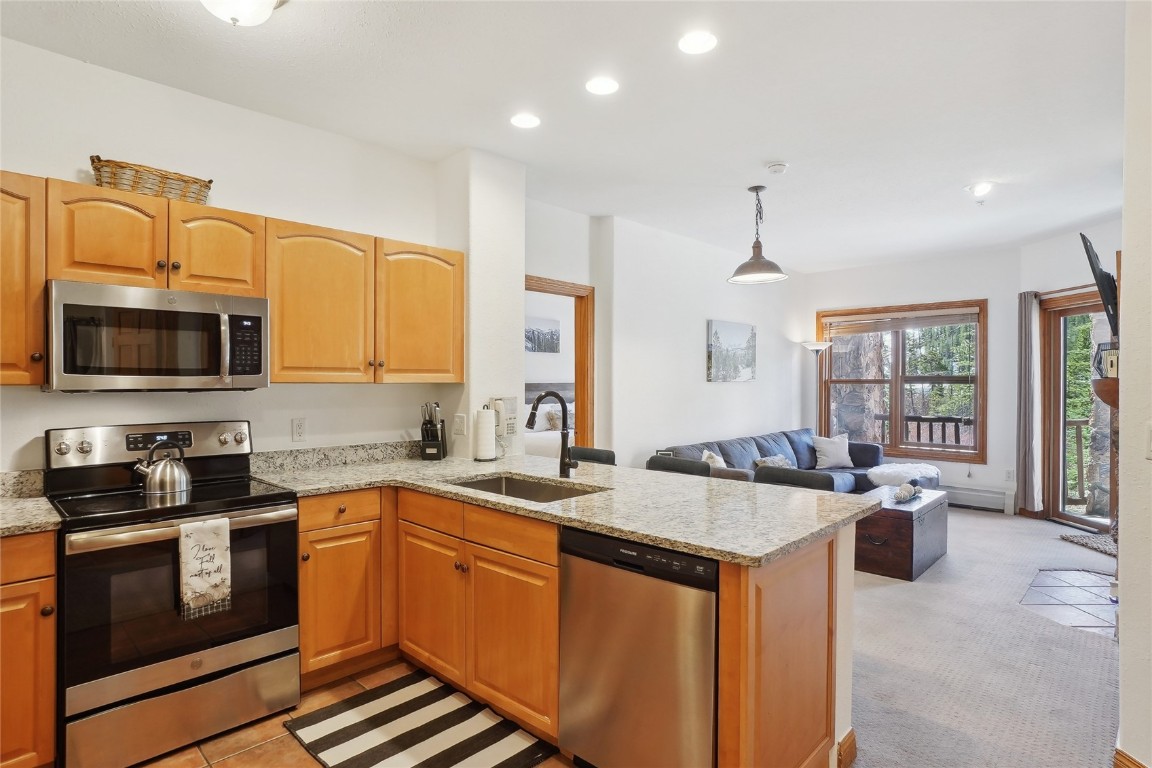 22714 Highway 6, Unit 5941 Keystone, CO 80435 - Photo 6 of 41 a kitchen with stainless steel appliances granite countertop a sink stove and microwave