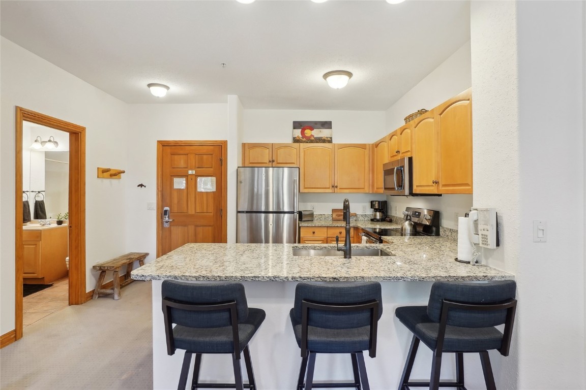 22714 Highway 6, Unit 5941 Keystone, CO 80435 - Photo 9 of 41 a kitchen with granite countertop wooden cabinets and dining table
