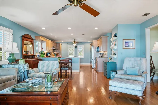 a kitchen with stainless steel appliances kitchen island granite countertop a refrigerator a oven a sink with island and chairs