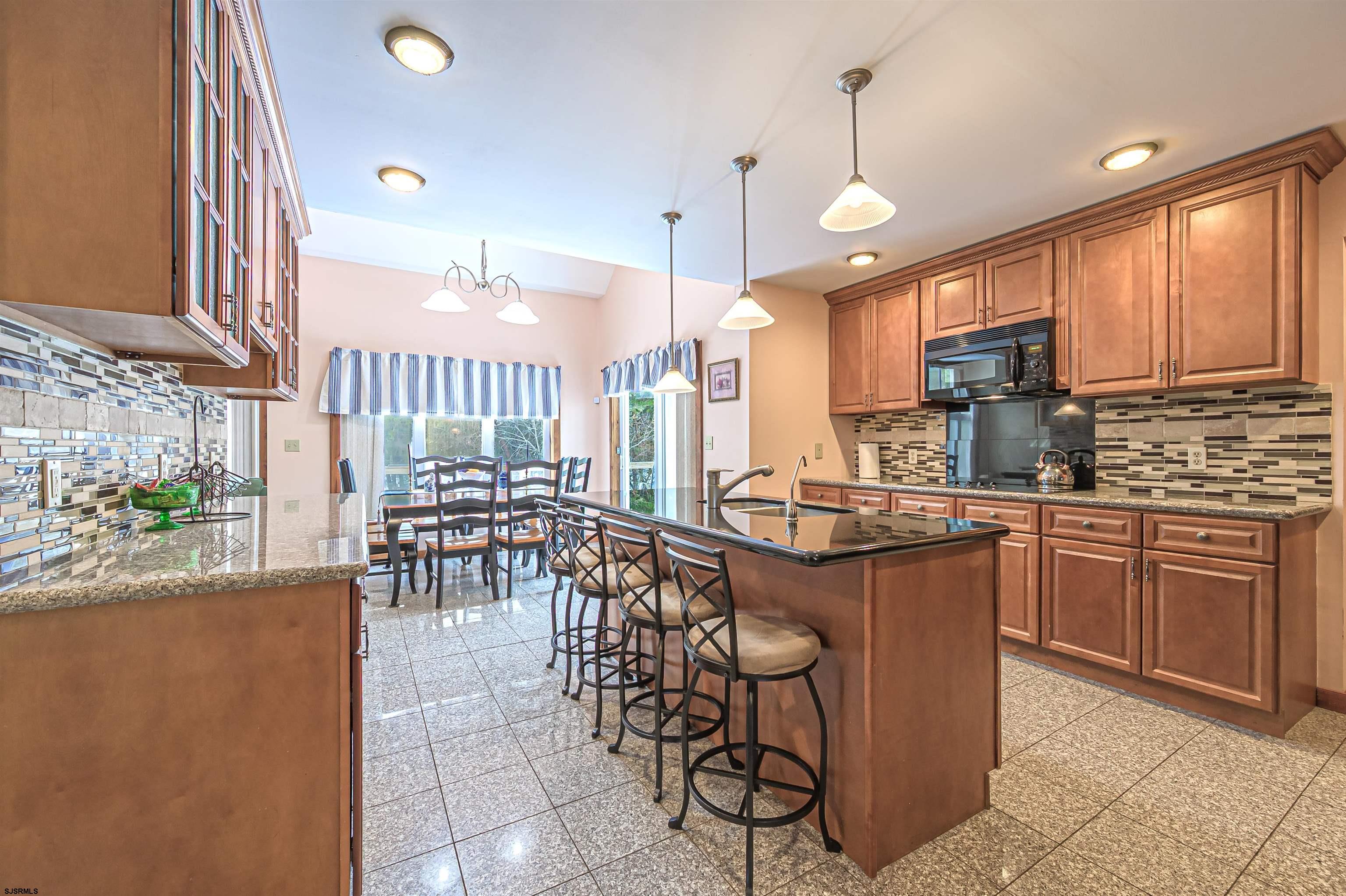 892 Hogbin Road Millville, NJ 08332 - Photo 12 of 63 a kitchen with stainless steel appliances granite countertop table chairs sink and cabinets