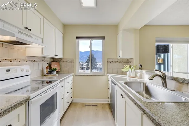 a kitchen with a sink stove top oven and cabinets