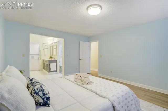 a bedroom with a large bed and wooden floor