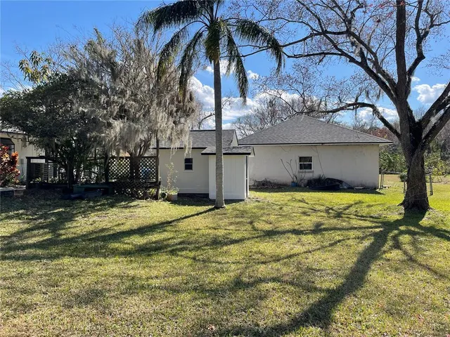 a view of a house with a yard and large tree