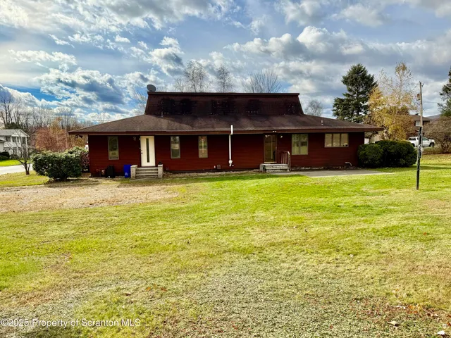 a view of a house with backyard and sitting area