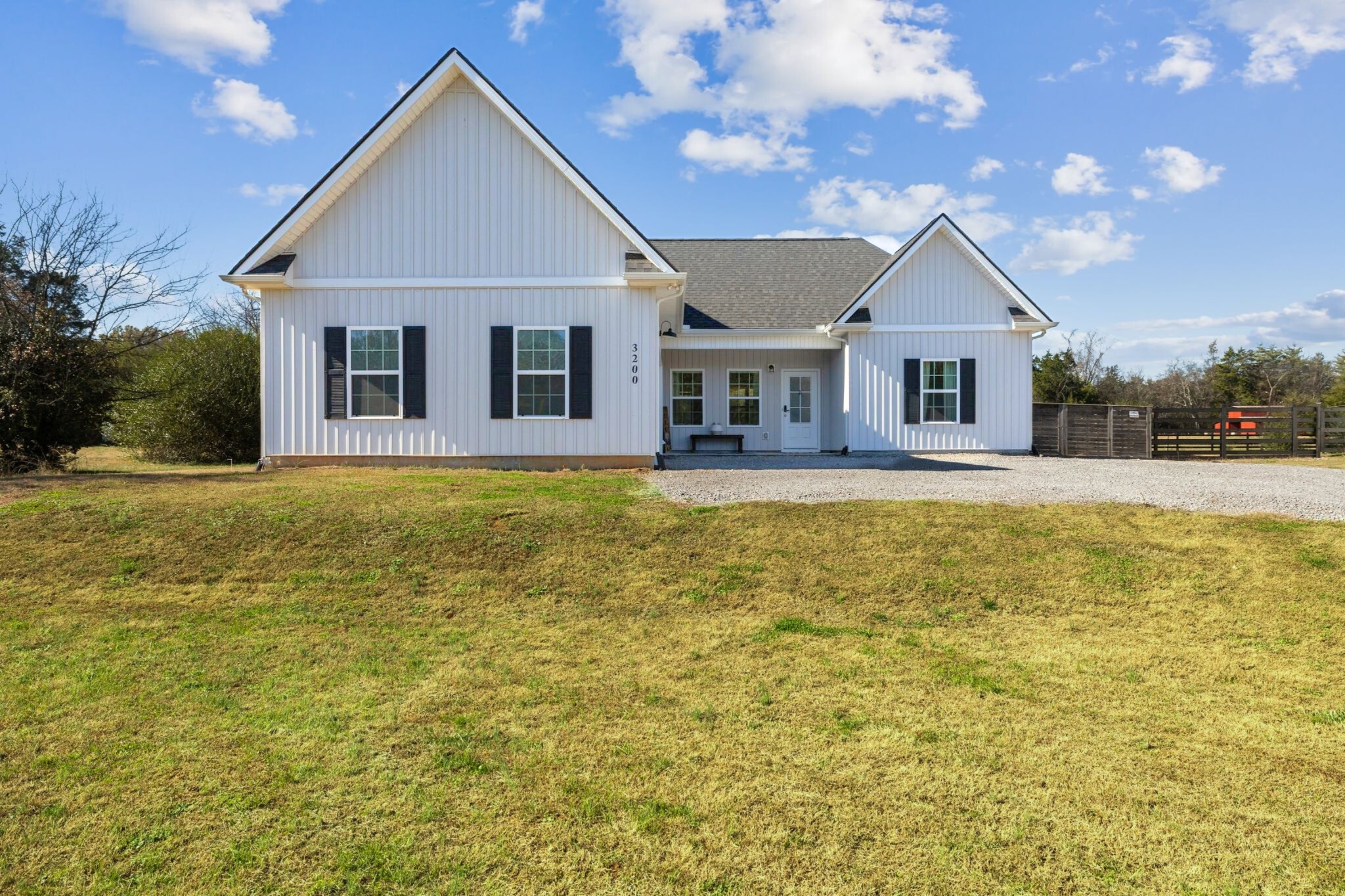a front view of a house with yard and green space