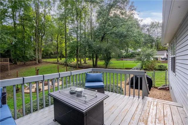 a view of a deck with furniture and trees around