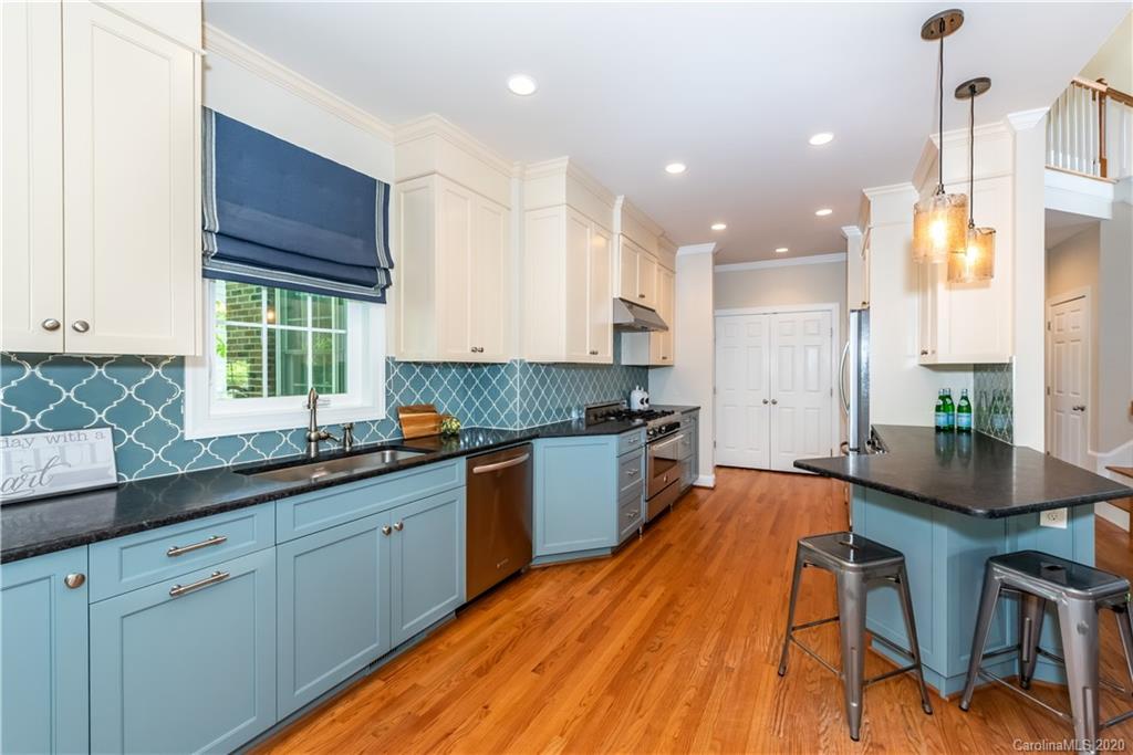 1315 Lilac Road Charlotte, NC 28209 - Photo 10 of 48 a kitchen with granite countertop wooden floors and white cabinets