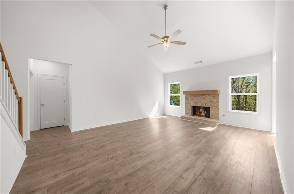 8905 Bethel Road Gainesville, GA 30506 - Photo 16 of 72 an empty room with wooden floor fireplace and windows