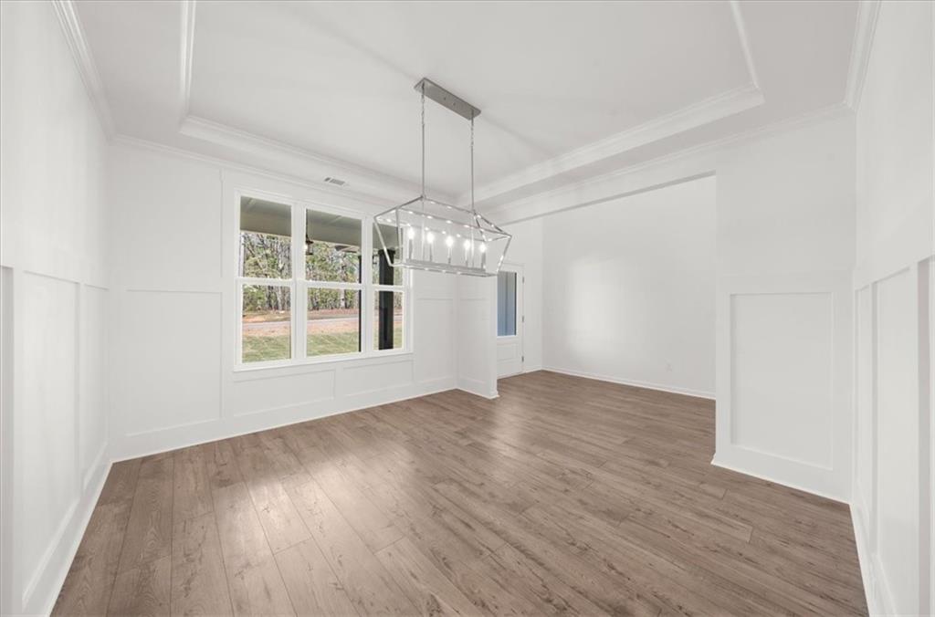 8905 Bethel Road Gainesville, GA 30506 - Photo 35 of 72 an empty room with wooden floor chandelier and windows