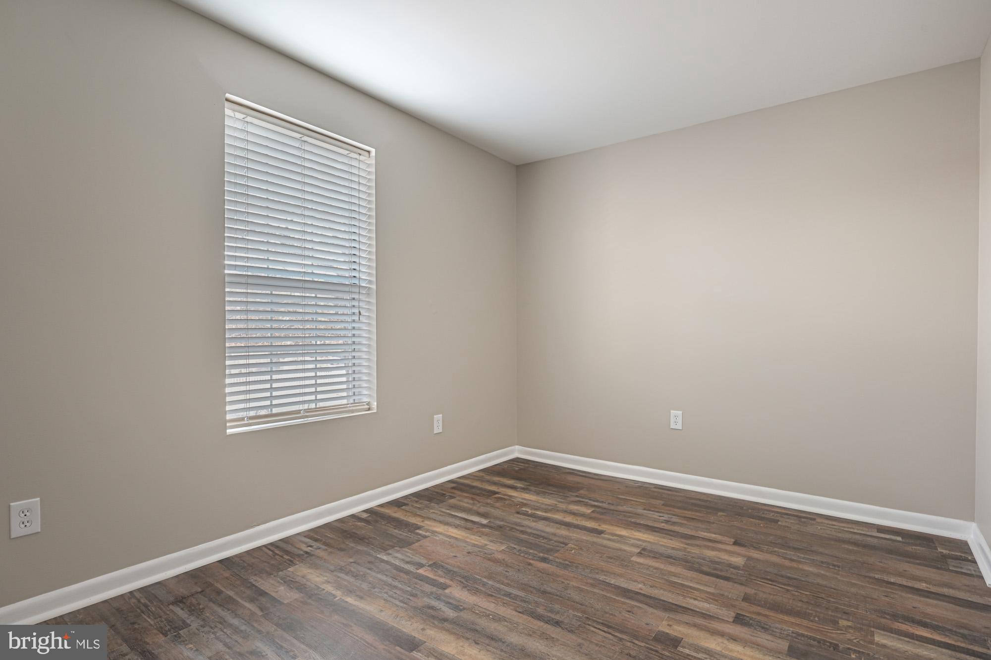 102 North Caroline Place, Unit 203 Dover, DE 19904 - Photo 11 of 12 wooden floor in an empty room with a window