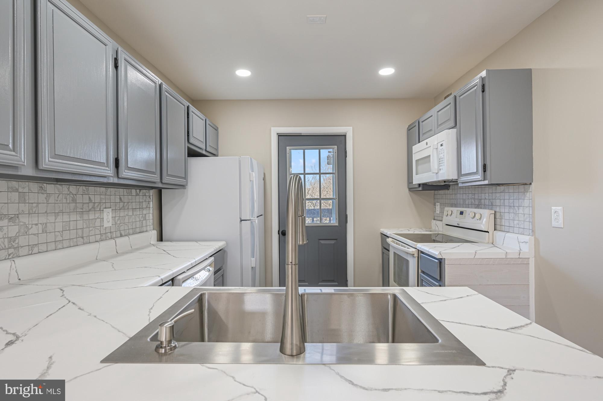 102 North Caroline Place, Unit 203 Dover, DE 19904 - Photo 5 of 12 a kitchen with a sink cabinets and stainless steel appliances