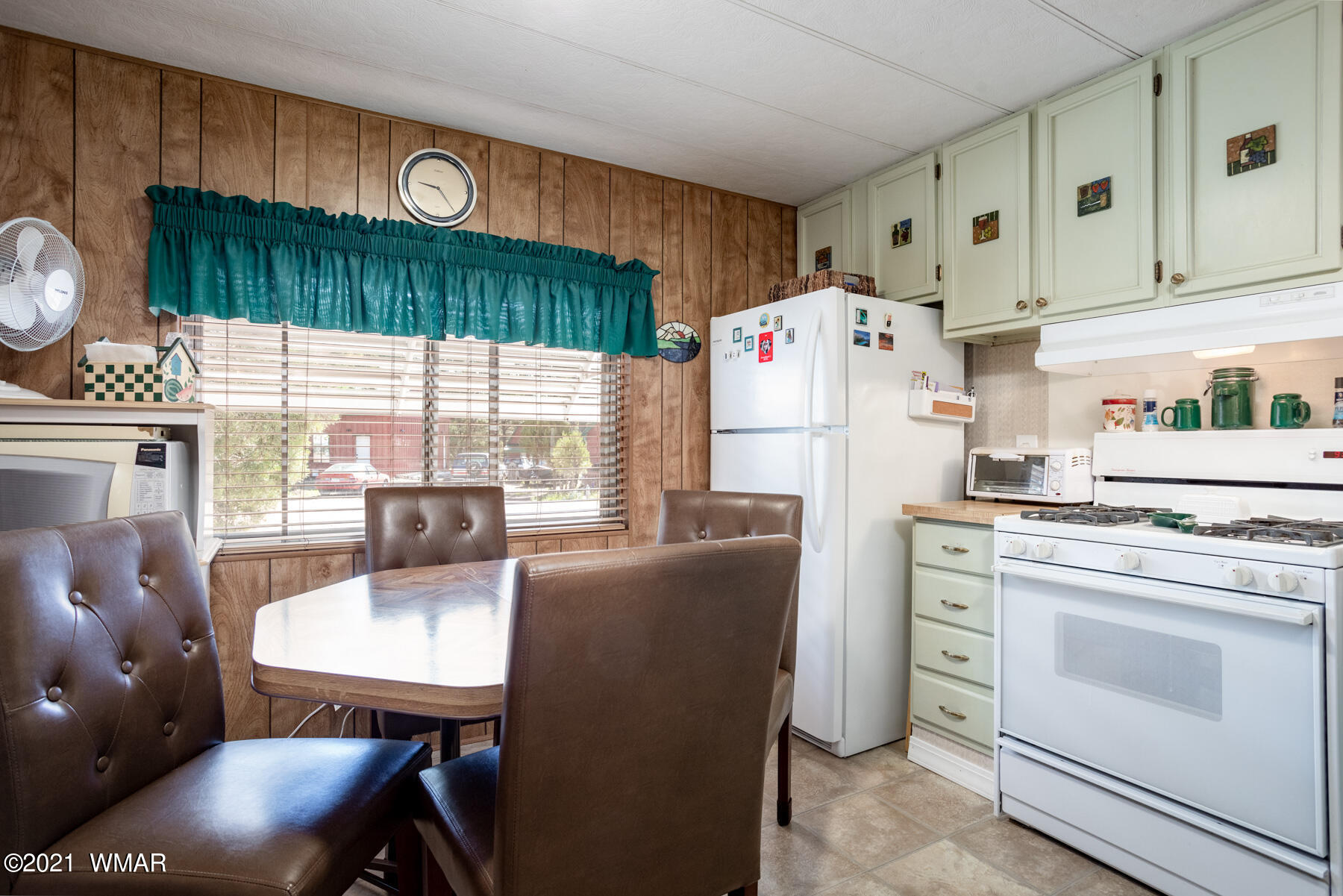 3536 Quail Run Road Overgaard, AZ 85933 - Photo 7 of 26 a kitchen with stainless steel appliances a table chairs and a refrigerator