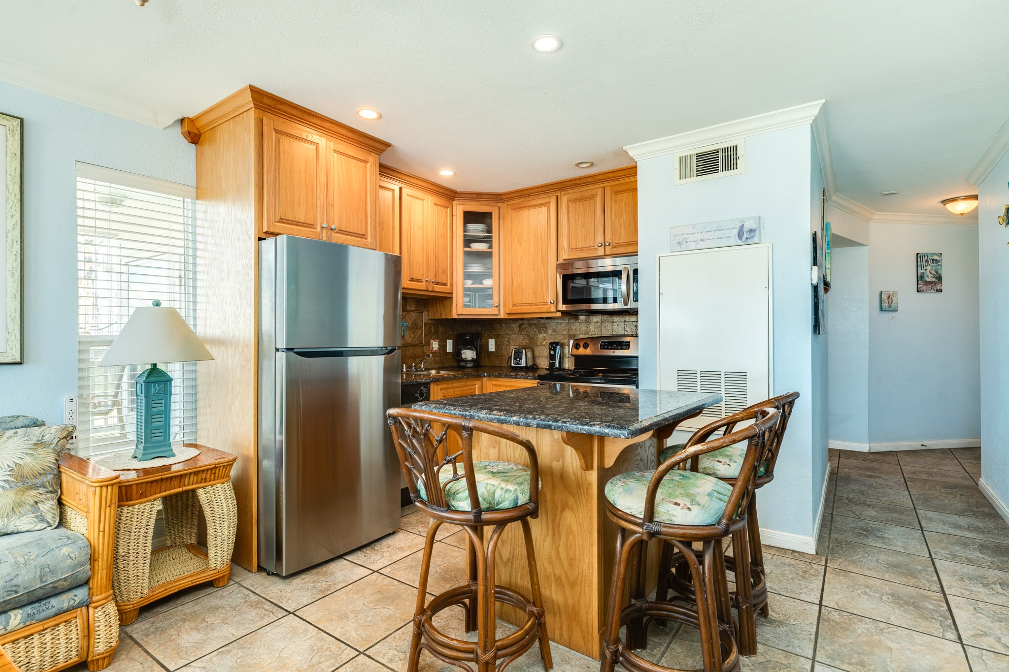10811 Termini-San Luis Pass Road, Unit 1201 Galveston, TX 77554 - Photo 12 of 25 a kitchen with stainless steel appliances granite countertop a refrigerator and a stove top oven