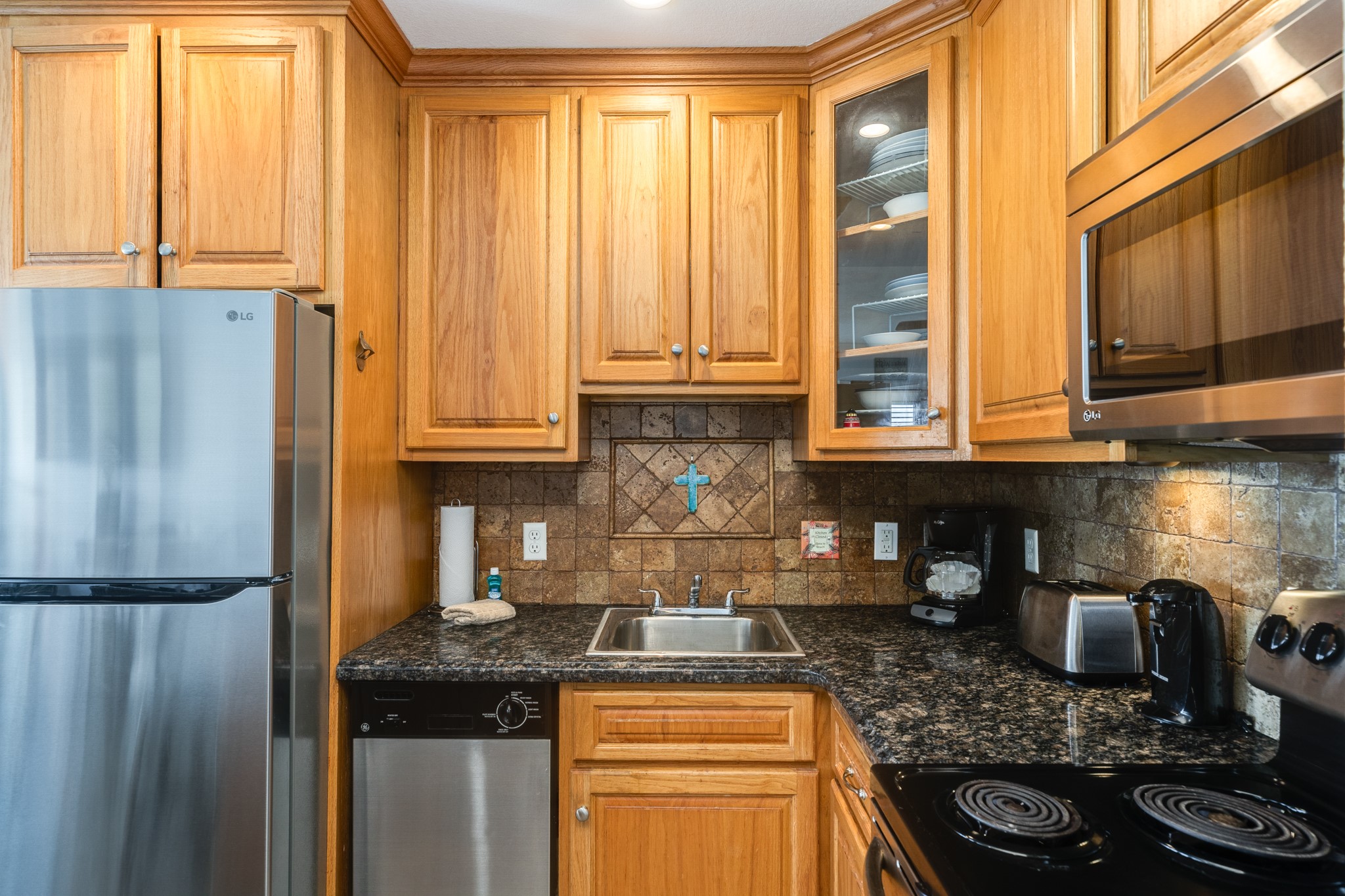 10811 Termini-San Luis Pass Road, Unit 1201 Galveston, TX 77554 - Photo 14 of 25 a kitchen with stainless steel appliances granite countertop a refrigerator and a stove