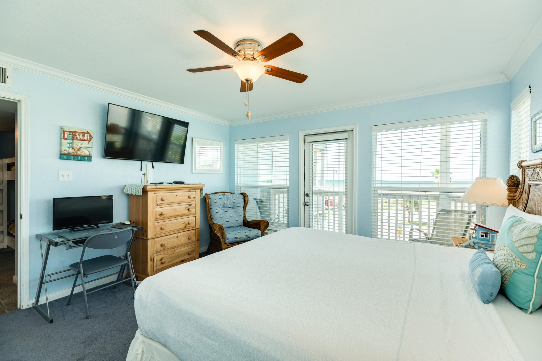 10811 Termini-San Luis Pass Road, Unit 1201 Galveston, TX 77554 - Photo 16 of 25 a bedroom with a bed a flat screen tv and a large window