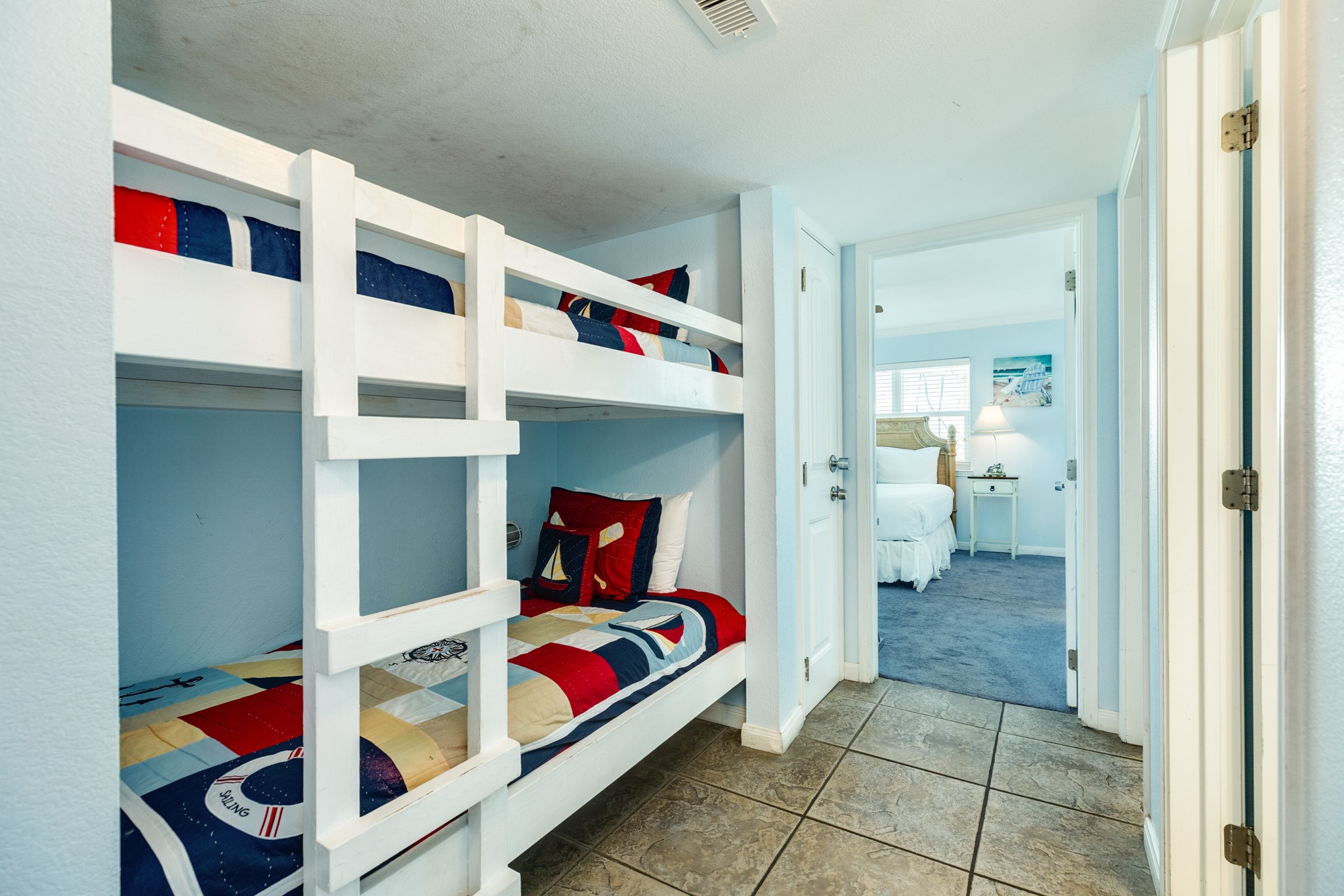 10811 Termini-San Luis Pass Road, Unit 1201 Galveston, TX 77554 - Photo 20 of 25 a bedroom with a bed and a view of en suite bathroom