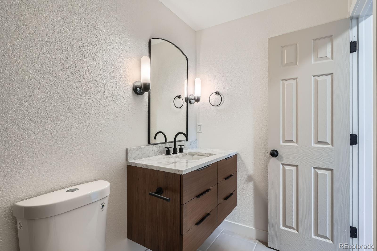 9455 West 37th Avenue Wheat Ridge, CO 80033 - Photo 18 of 33 a bathroom with a sink toilet and mirror