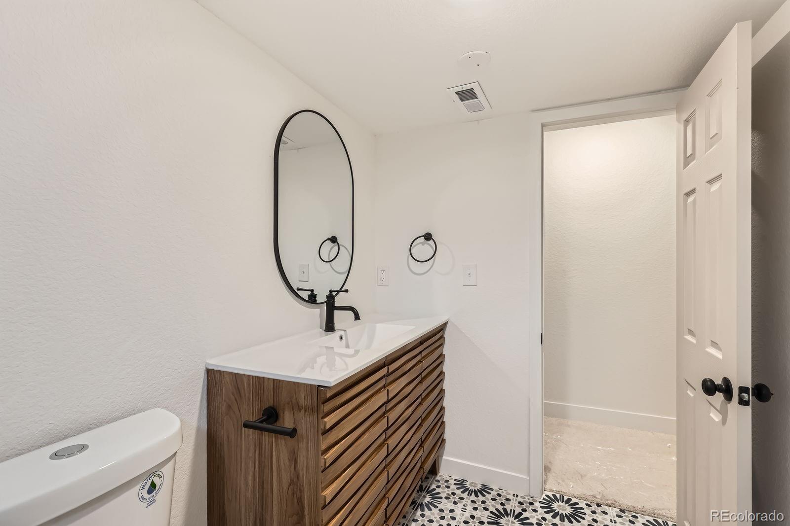9455 West 37th Avenue Wheat Ridge, CO 80033 - Photo 23 of 33 a bathroom with a sink a toilet and shower