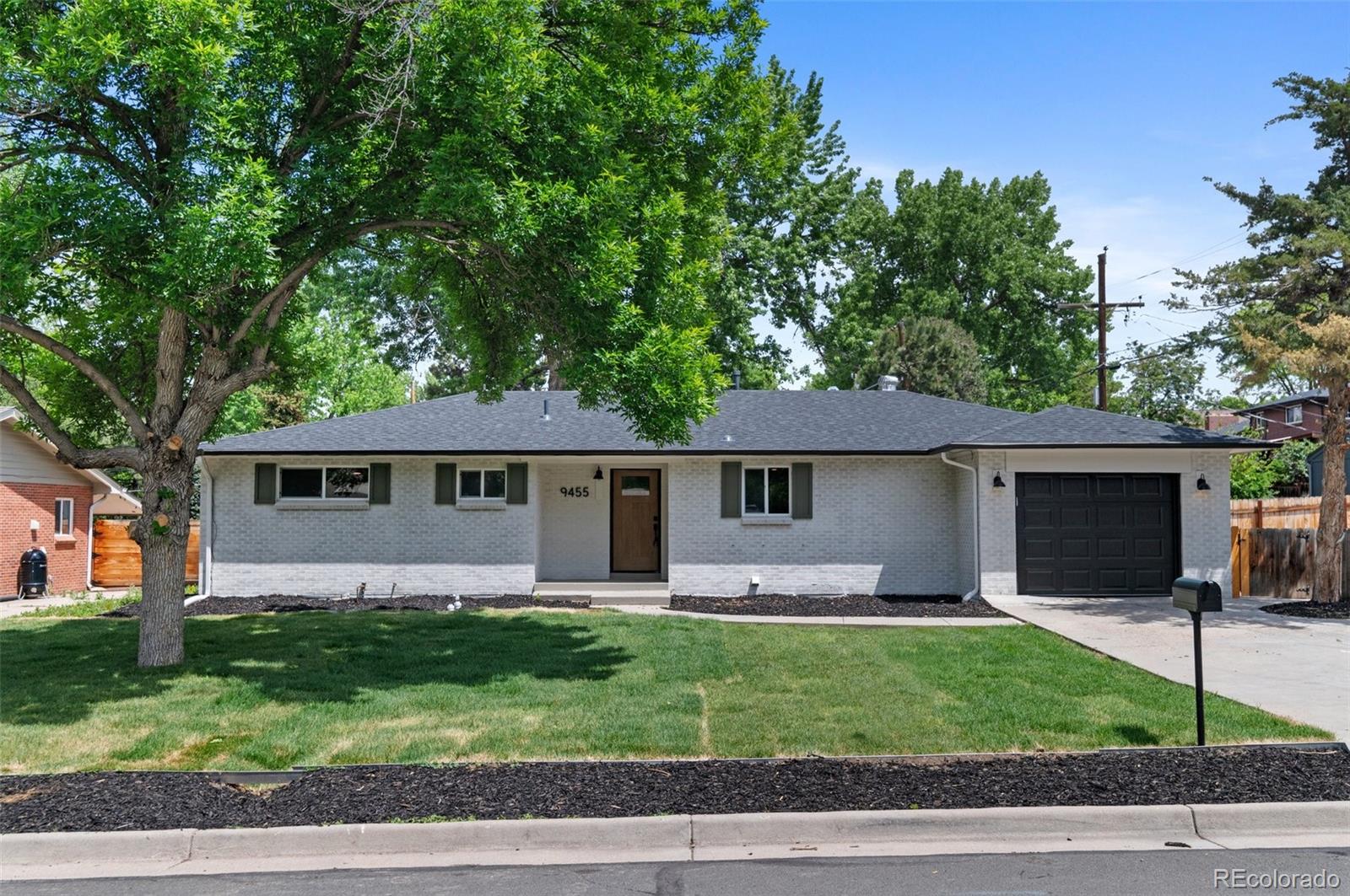9455 West 37th Avenue Wheat Ridge, CO 80033 - Photo 31 of 33 a front view of a house with a garden and trees