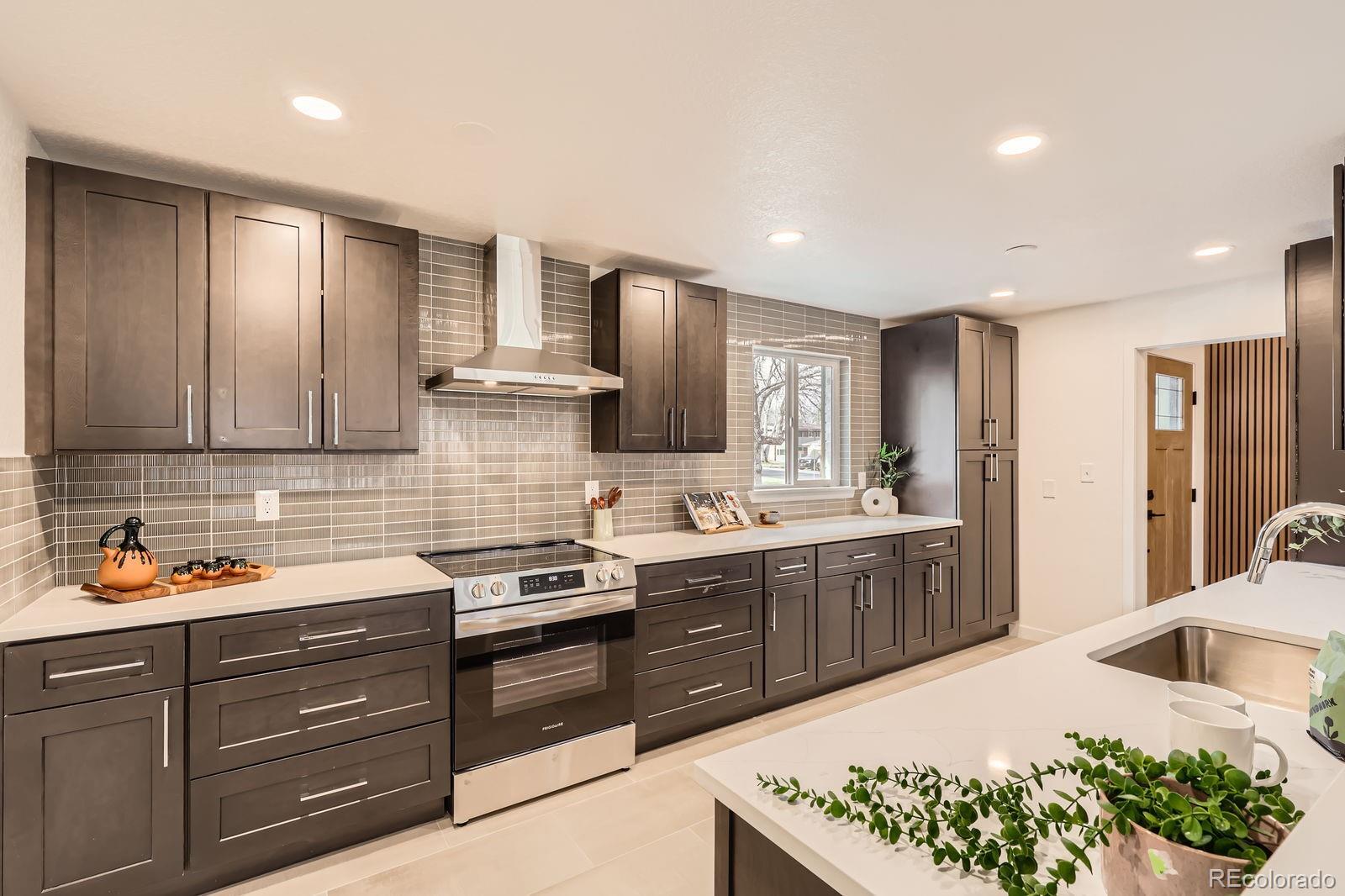 9455 West 37th Avenue Wheat Ridge, CO 80033 - Photo 7 of 33 a kitchen with stainless steel appliances granite countertop a sink stove and cabinets