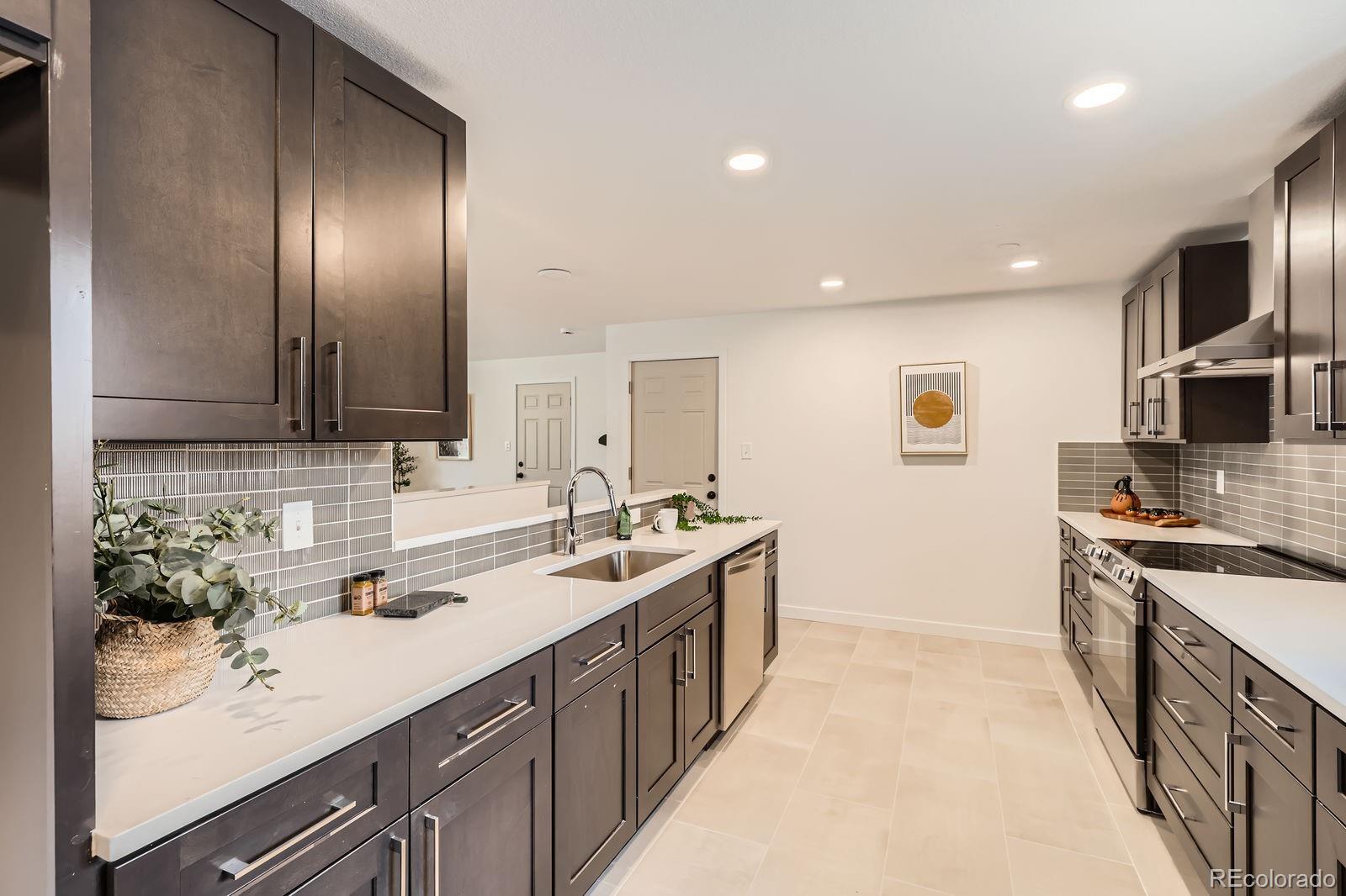 9455 West 37th Avenue Wheat Ridge, CO 80033 - Photo 9 of 33 a kitchen with stainless steel appliances granite countertop a sink and stove top oven