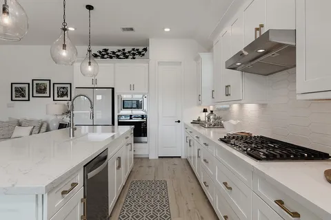 a kitchen with stainless steel appliances granite countertop a sink stove and refrigerator