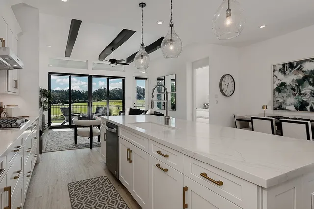a kitchen with stainless steel appliances granite countertop a stove and a view of living room