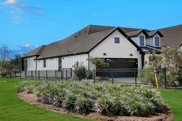 a house that is sitting in the grass with large trees
