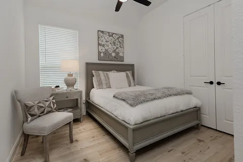 a bed sitting in a bedroom next to a window