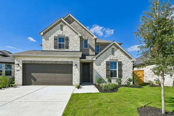 a front view of a house with a yard and garage