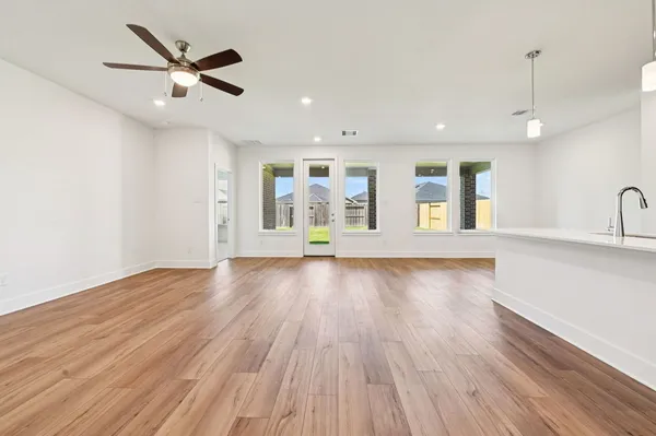 a view of an empty room with window and wooden floor