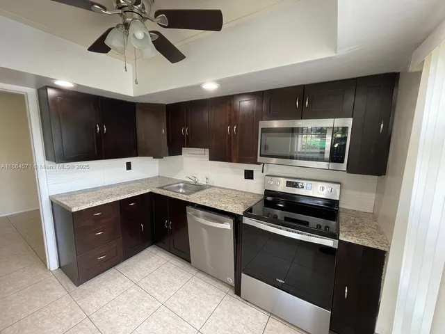 a kitchen with stainless steel appliances granite countertop a stove and a microwave