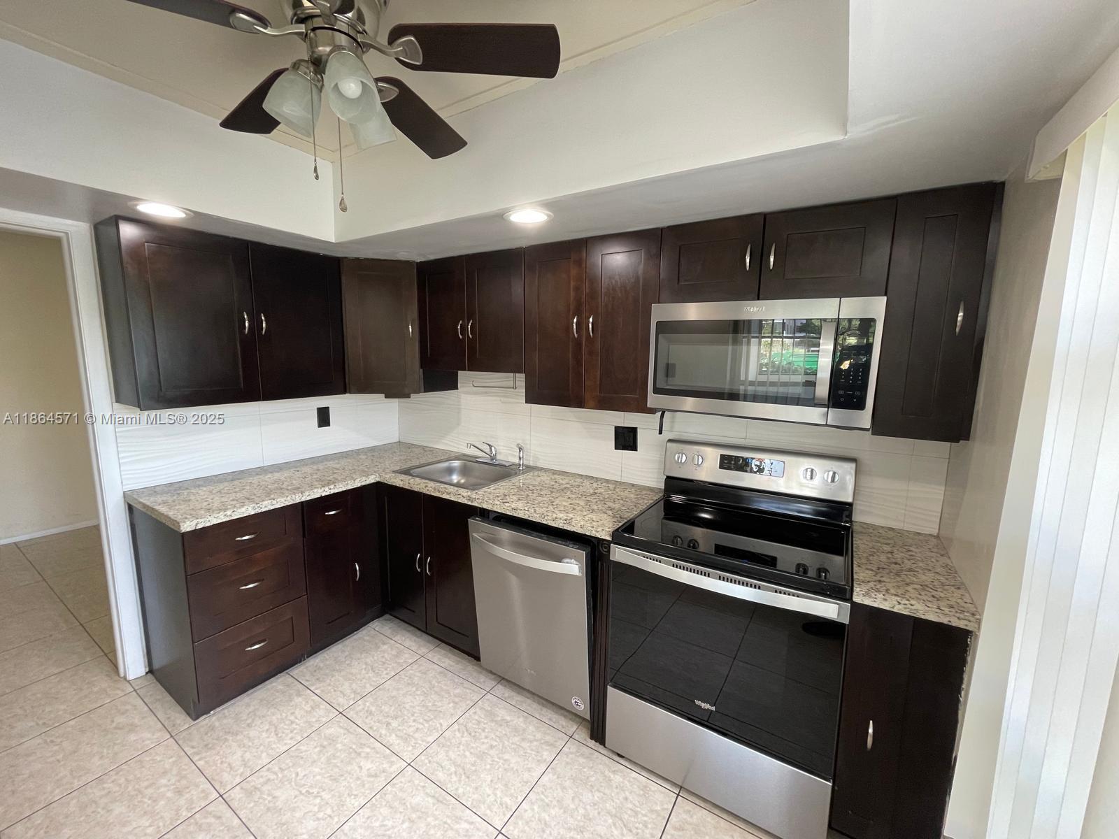 a kitchen with stainless steel appliances granite countertop a stove and a microwave