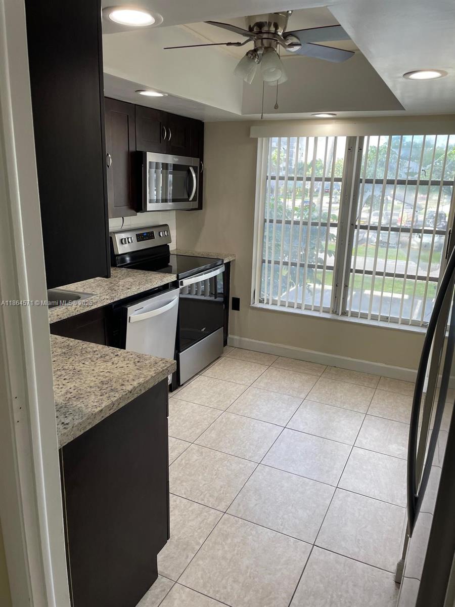 4164 Inverrary Drive, Unit 215 Lauderhill, FL 33319 - Photo 2 of 27 a kitchen with stainless steel appliances a stove a sink and a microwave