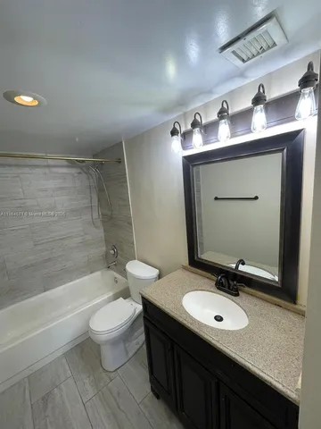 a bathroom with a sink double vanity mirror and toilet