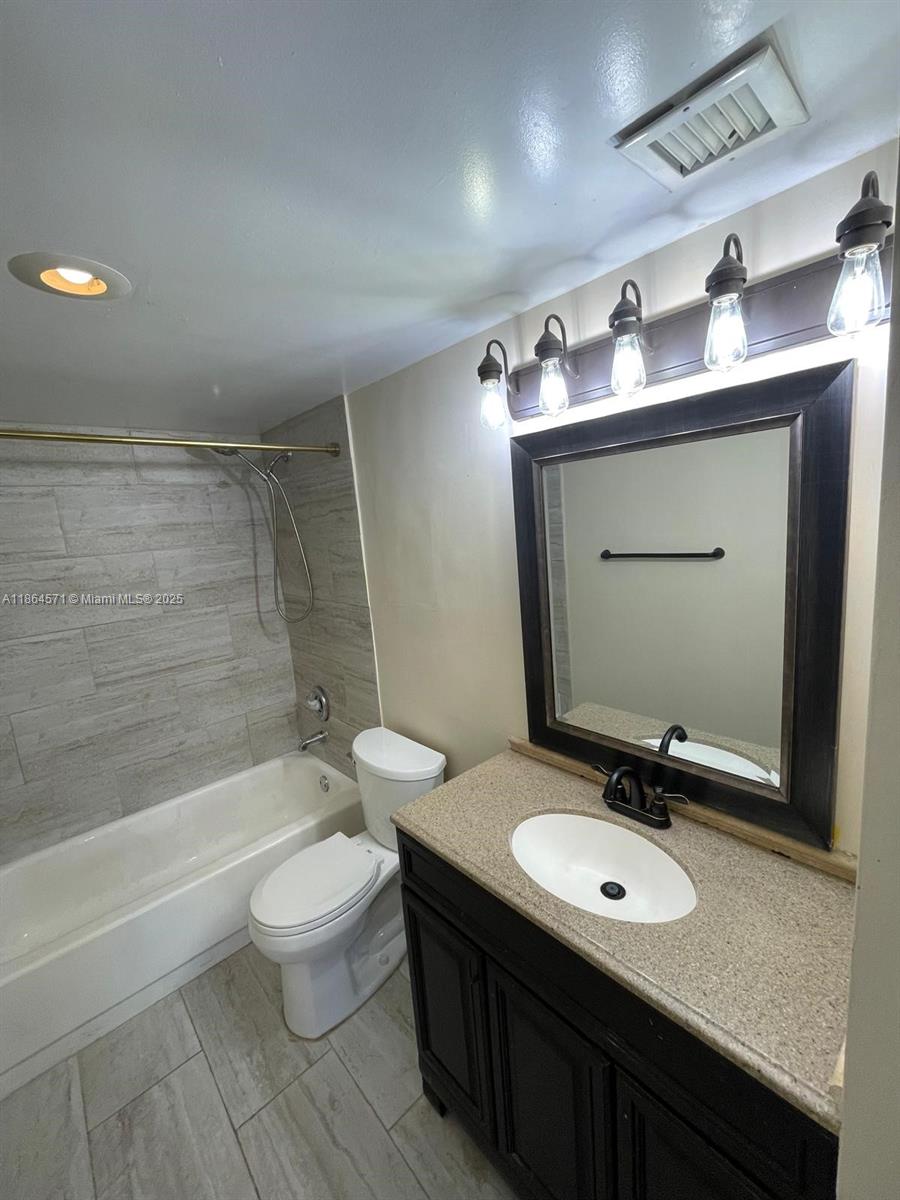 4164 Inverrary Drive, Unit 215 Lauderhill, FL 33319 - Photo 23 of 27 a bathroom with a sink double vanity mirror and toilet