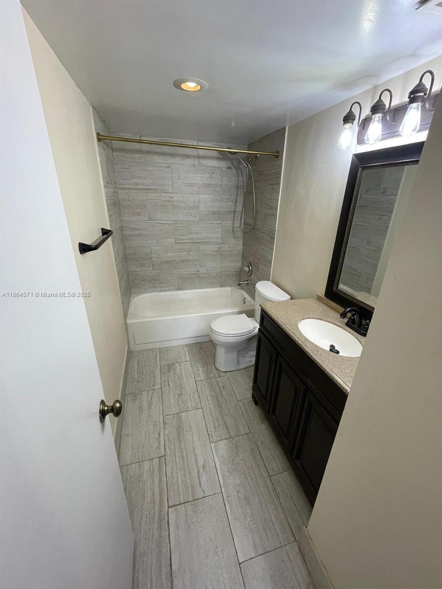 4164 Inverrary Drive, Unit 215 Lauderhill, FL 33319 - Photo 6 of 27 a bathroom with a sink a toilet a mirror and shower