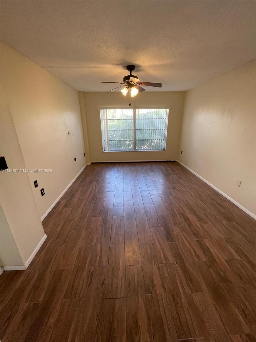 4164 Inverrary Drive, Unit 215 Lauderhill, FL 33319 - Photo 8 of 27 wooden floor in an empty room with a window
