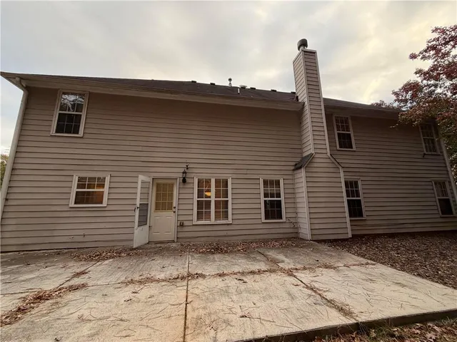 a side view of a house with a wooden fence