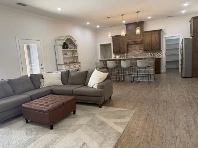 a living room with furniture kitchen view and a large window