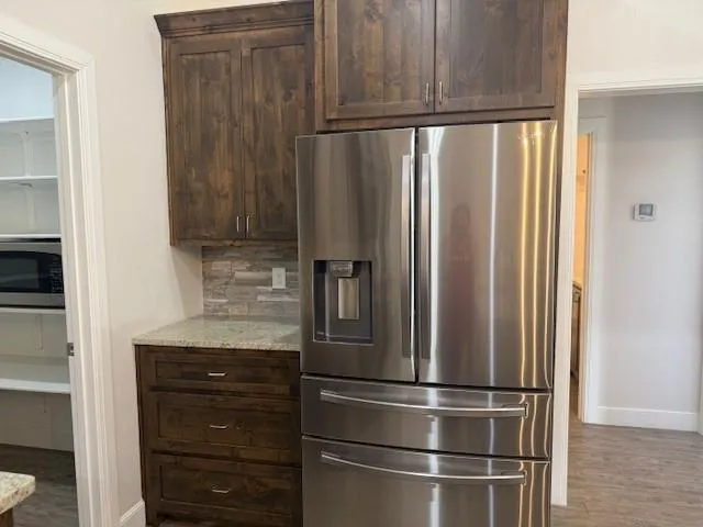 a metallic refrigerator freezer sitting in a kitchen