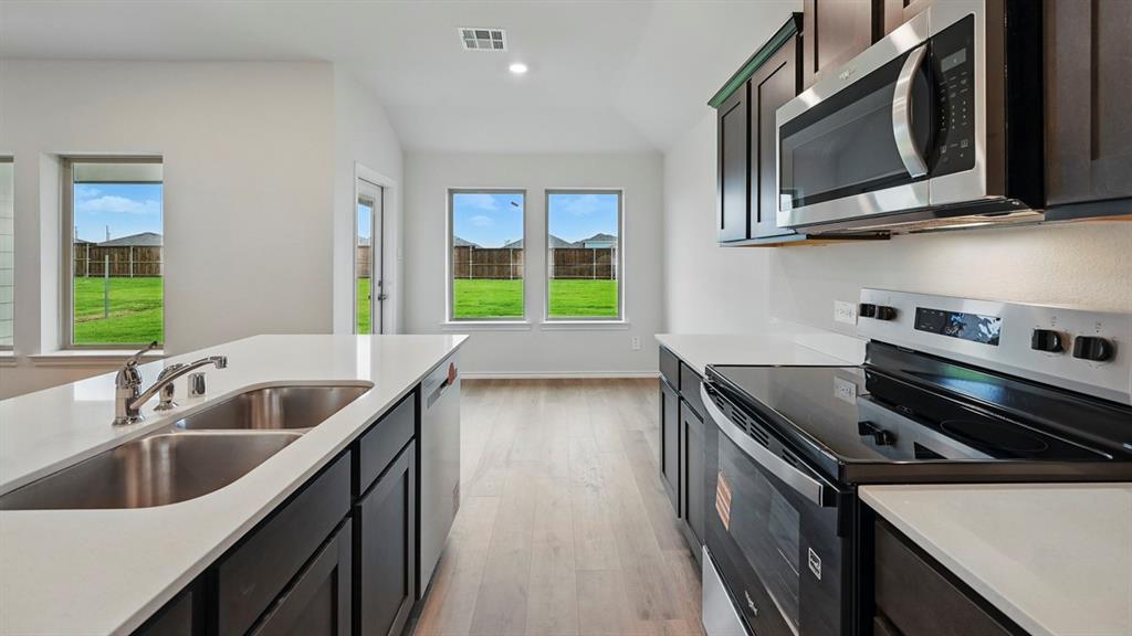 511 Lantana Road Princeton, TX 75407 - Photo 22 of 35 a kitchen with stainless steel appliances a sink stove and microwave